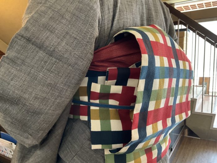 近江ちぢみの麻に秋色の格子の帯が可愛らしい。